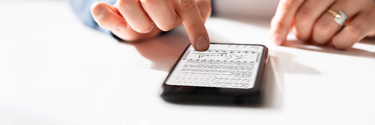 Photo of someone digitally signing a document on a mobile touch screen with their finger.