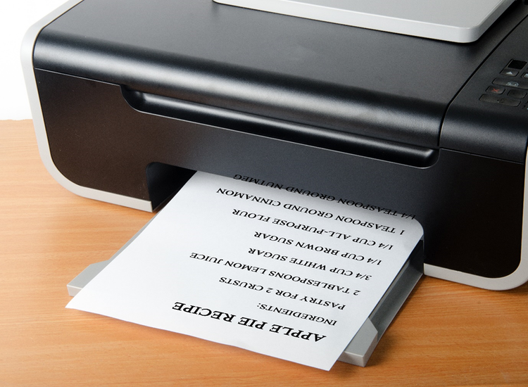 Photo of a printer printing out page with a recipe for apple pie.