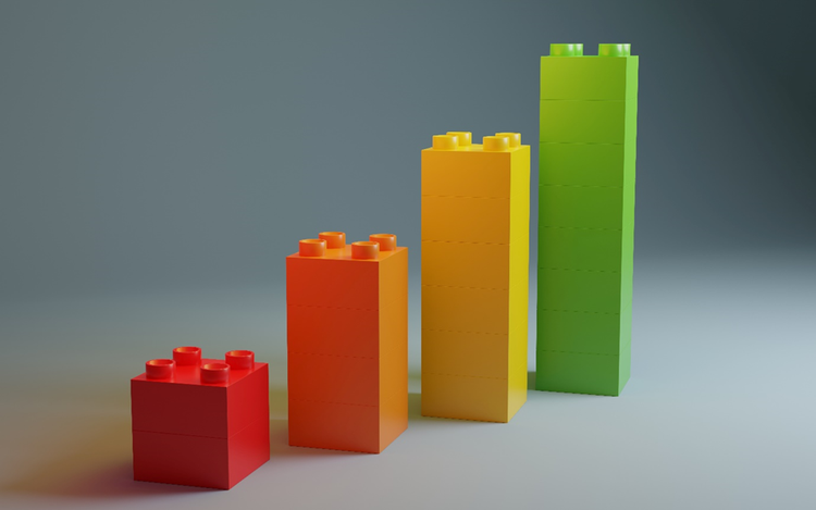 Illustration of four stacks of coloured toy blocks progressing in height. The shortest stack is red, the second orange, the third yellow, and the fourth, and tallest, is green.