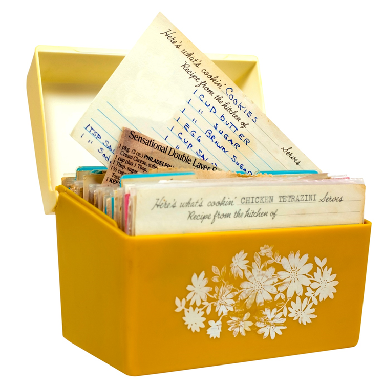 Photo of a yellow floral recipe box from the 19602 with handwritten recipes on index cards.