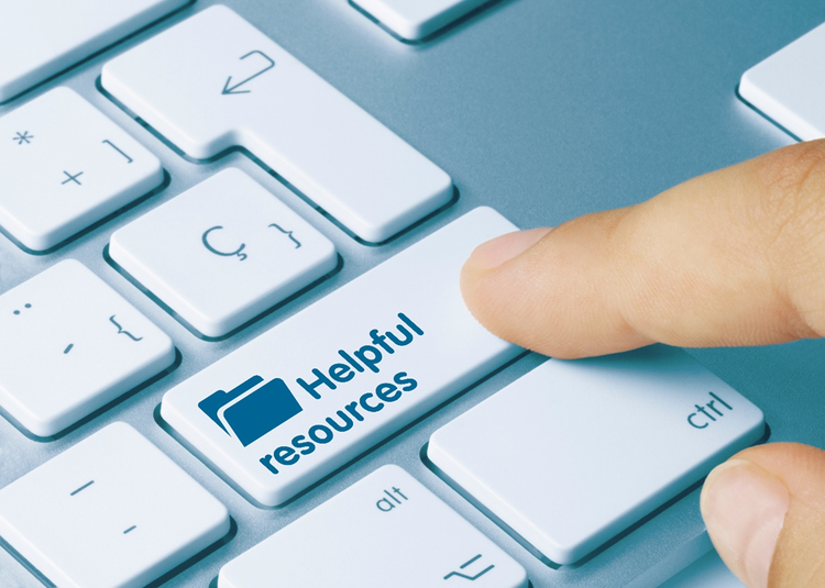 Photo of a section of keyboard. A person's finger is pressing on a button with a folder icon and the words, "helpful resources".