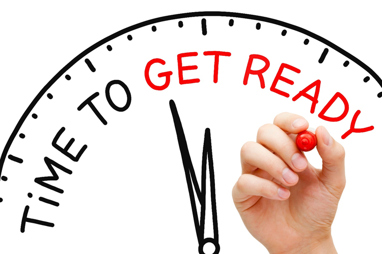 Photo of a person's hand writing on a drawing of a clock face with the words "Time to get ready".