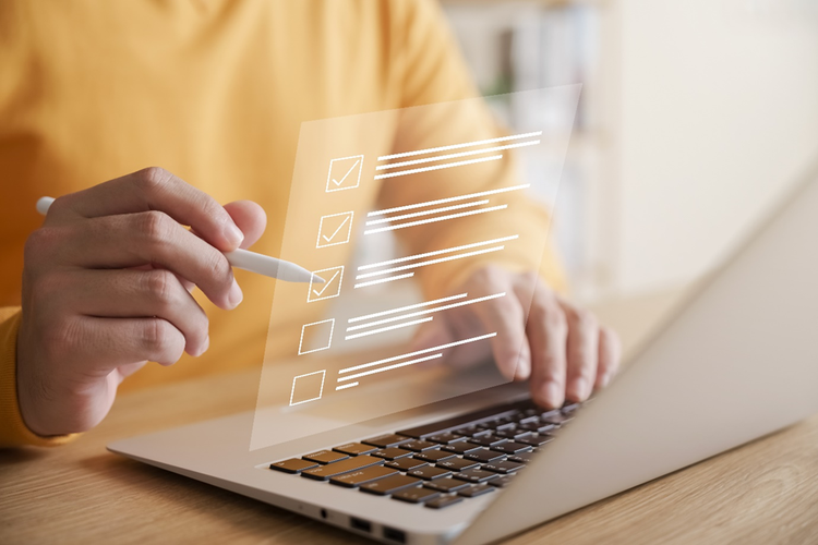 Person sitting at a laptop with a pen and overlaid with a conceptual diagram of ticking off a checklist.