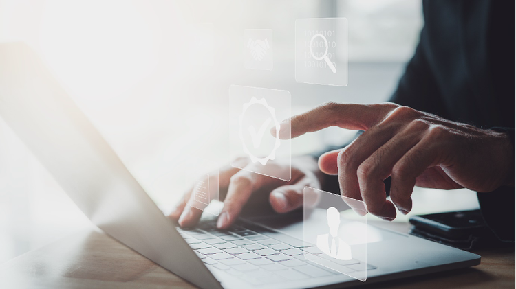 Person typing at laptop with rising digital images symbolising business implementation considerations.