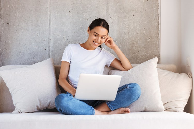 A person sitting on a couch with a computer