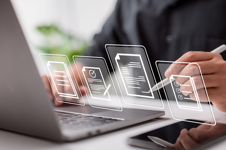 Photo of a person sitting at laptop holding a stylus to sign conceptual images of various types of documents.