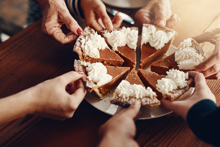 A pie sliced into pieces that are being taken by the hands of different generations.