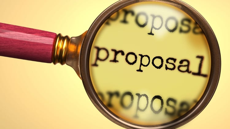 Magnifying glass enlarging and focusing on the word "Proposal".