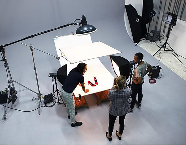 Aerial shot of product photographers staging a pair of red high heels