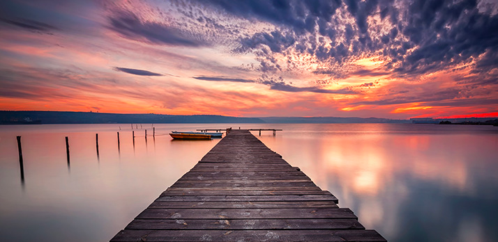 Beautiful landscape photo of a pier keeping in touch to the horizon