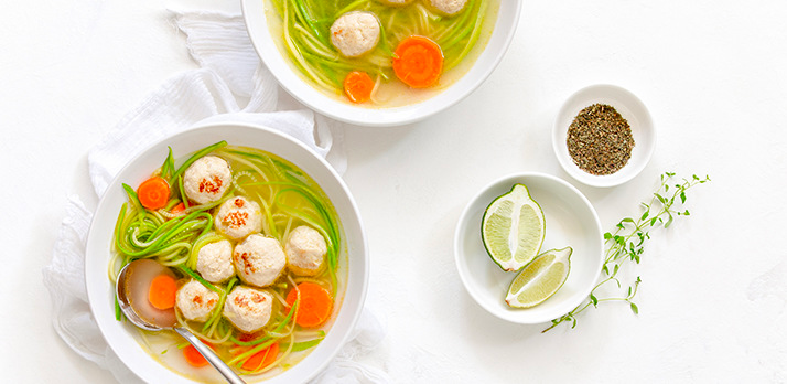 Artfully staged food picture of dumpling soup with limes and seasoning