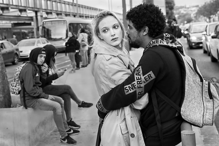 Couple embracing each other while waiting at bus stop