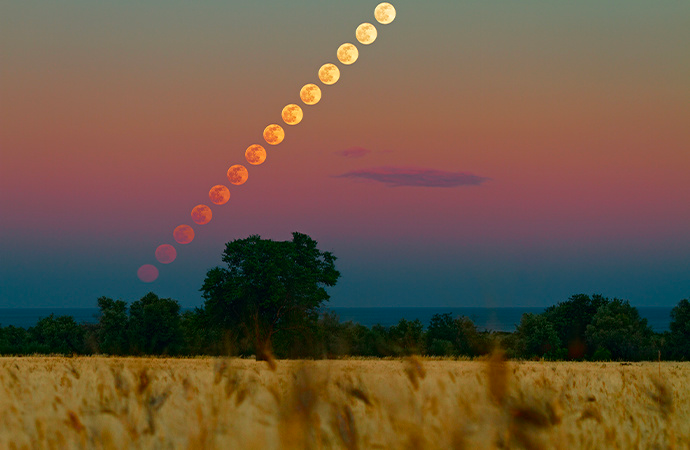 Time-lapse astronomy photo of the moon travelling across the sky.