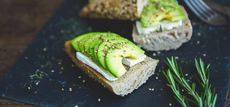 Mouth-watering image of an open-faced avocado and cream cheese sandwich