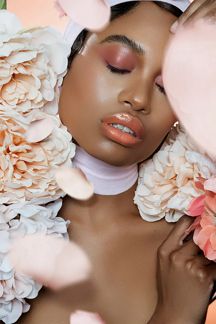 A model posing while surrounded by flower-looking props