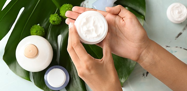 Skincare cream product being held by an individual