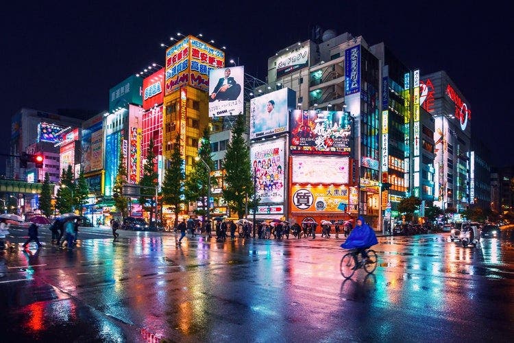 Night-time view of city hoarding illuminated by neon lights