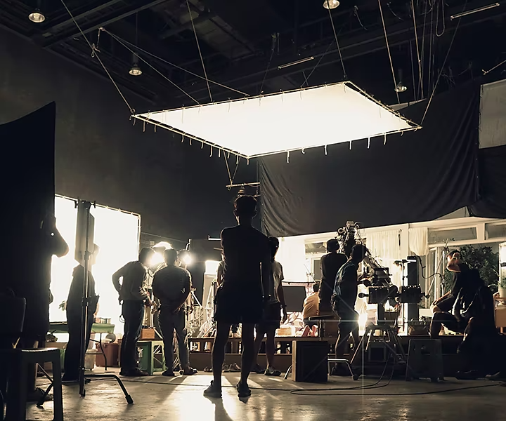 A production set with numerous people setting up equipment for a shoot