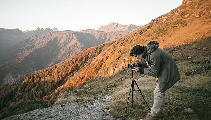 A photo of a photographer taking a photo on the side of a mountain