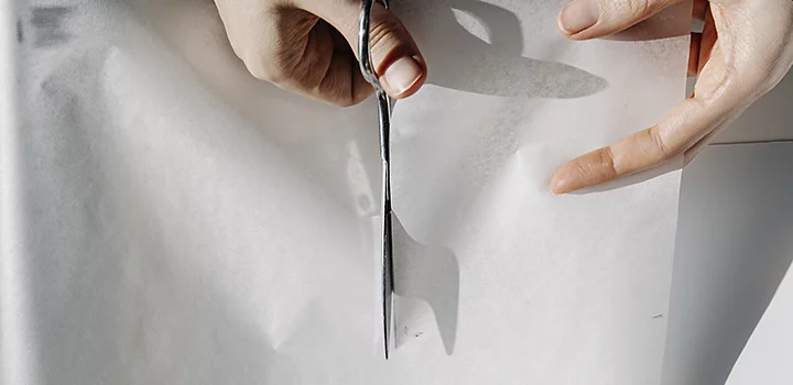 A person cutting fabric for a lightbox