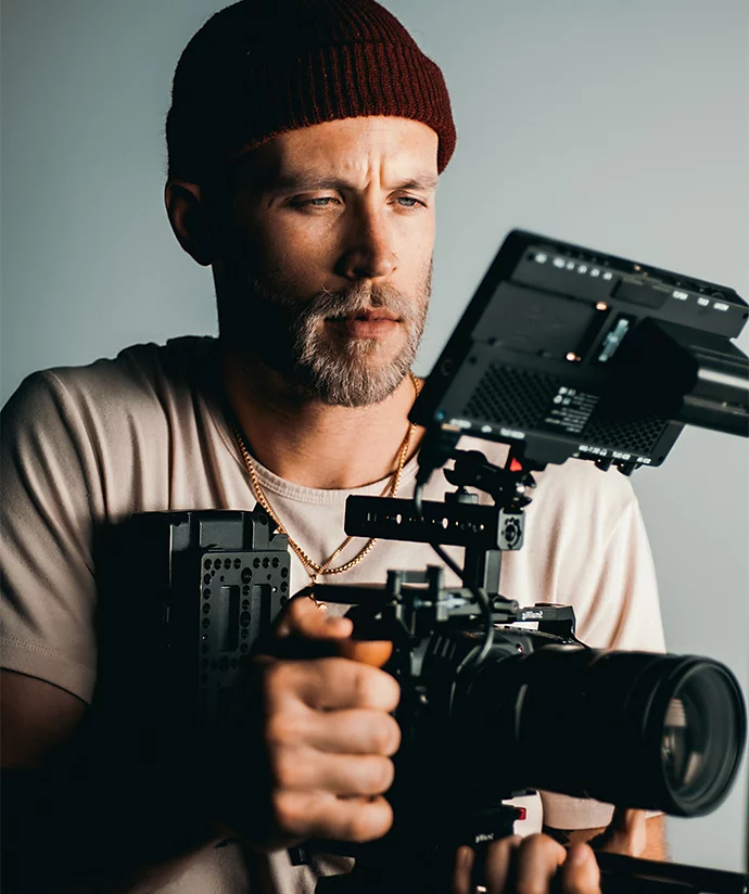 A videographer setting up a camera on a tripod for a commercial