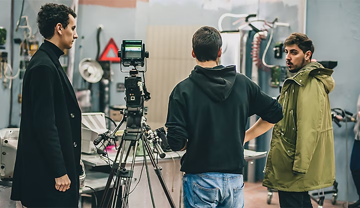 A production crew setting up a camera on a tripod for a video shoot