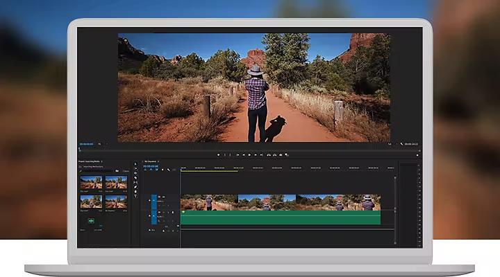 A person walking down a hiking trail in a video being editing on a laptop computer using Adobe Premiere Pro