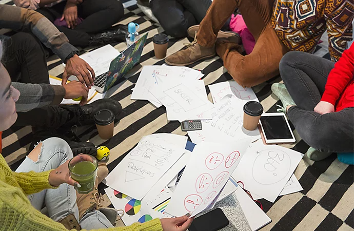 Adeptes de la réflexion conceptuelle en pleine séance de brainstorming sur le sol