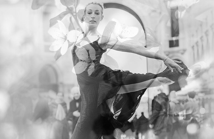 Double exposure of female dancer in the street layered with image of flowers.