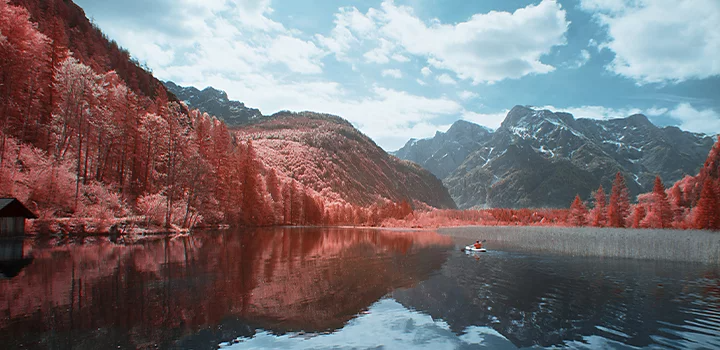 Photo infrarouge d’une rivière traversant une forêt avec des montagnes en arrière-plan