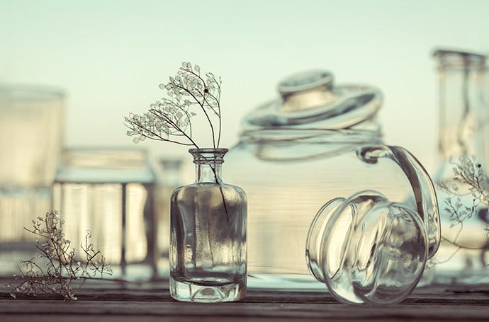 Assortment of glass containers with dried plant stems captured with still-life photography