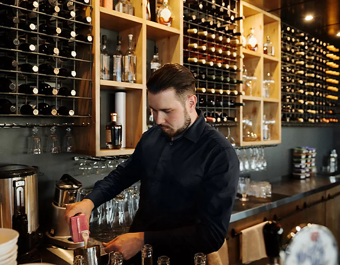 Een acteur die een drankje klaarmaakt in een koffiecafé voor een commercial