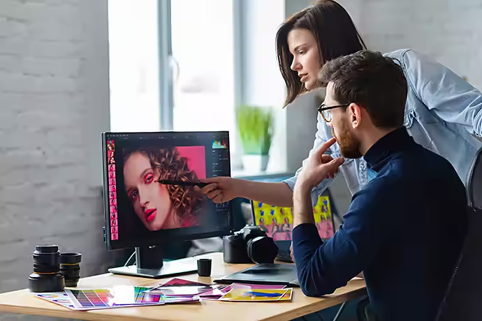 Professionals photographer and retoucher retouching images on a graphics tablet teamwork in a professional photo studio