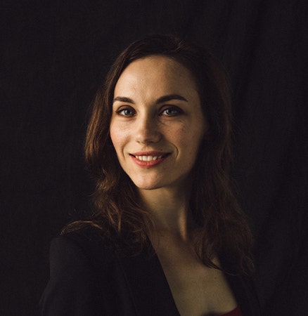 Professional headshot of a woman against a dark background