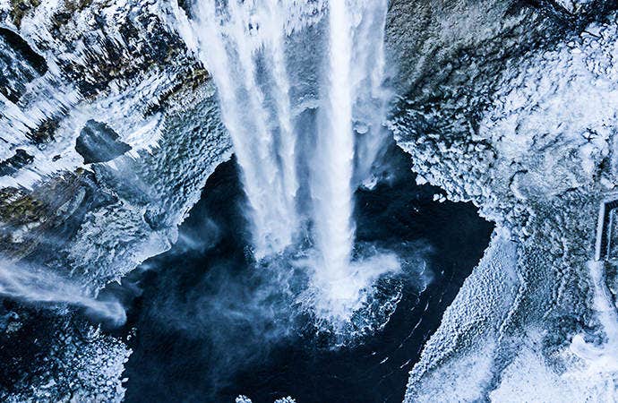 Photo of snowy winter waterfall taken from above.