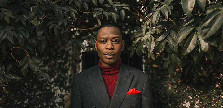 Model dressed in a suit posing in front of trees