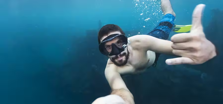 Homme sous l'eau devant une caméra GoPro