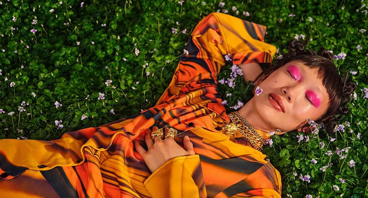 Smiling woman lying in a field of flowers