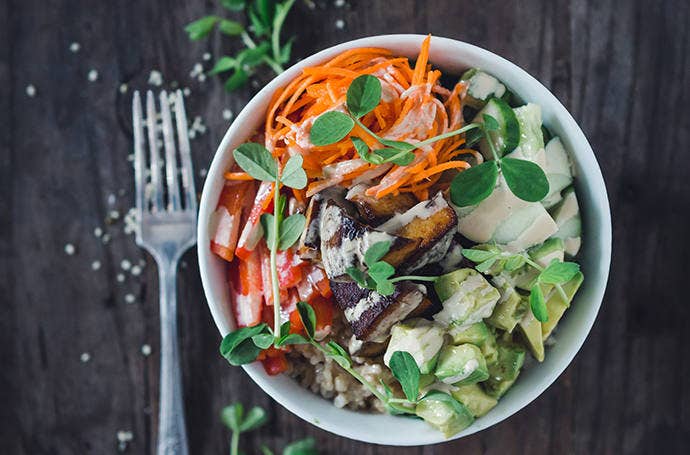 Staged food photo of a salad in white bowl with fork