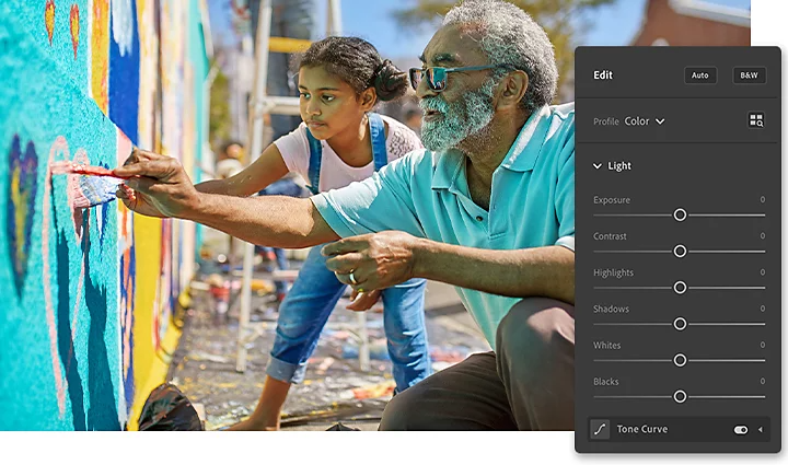 A father and his kid painting a colorful mural on a wall