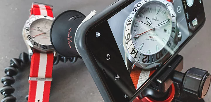 Smartphone with a camera lens shooting a product photo of a watch