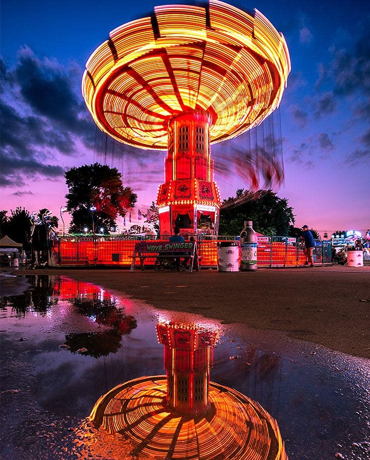 A motion blur photo of a carnival ride spinning at night