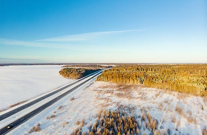 Aerial photo of a highway cutting through a snowy landscape