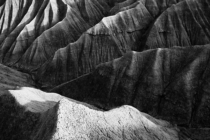 Una foto aerea in scala di grigi di un terreno di montagna roccioso