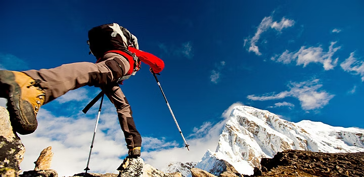 Escursionista in movimento verso una cima innevata