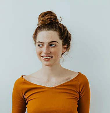 A portrait photo of a person with freckles and red hair.