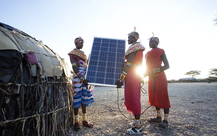 People holding a solar panel in an African tribe