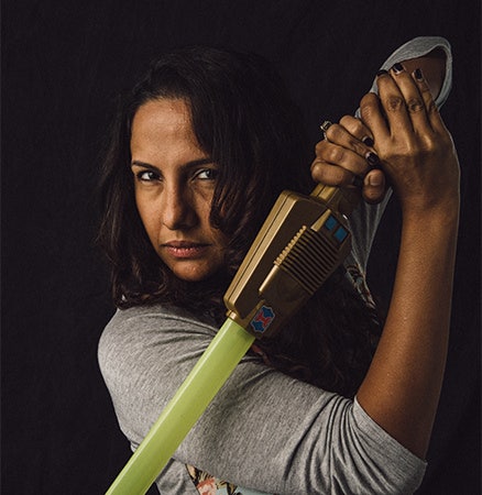 Fotografía del rostro de una mujer con un sable de luz