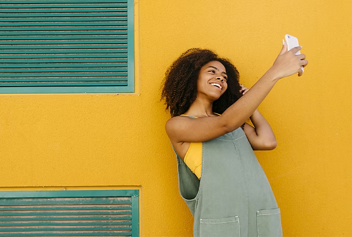 Una persona empleando su teléfono para grabar un video de sí misma para su videoblog