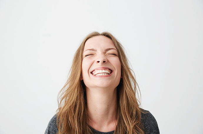 Frau stark lächelnd vor weißem Hintergrund